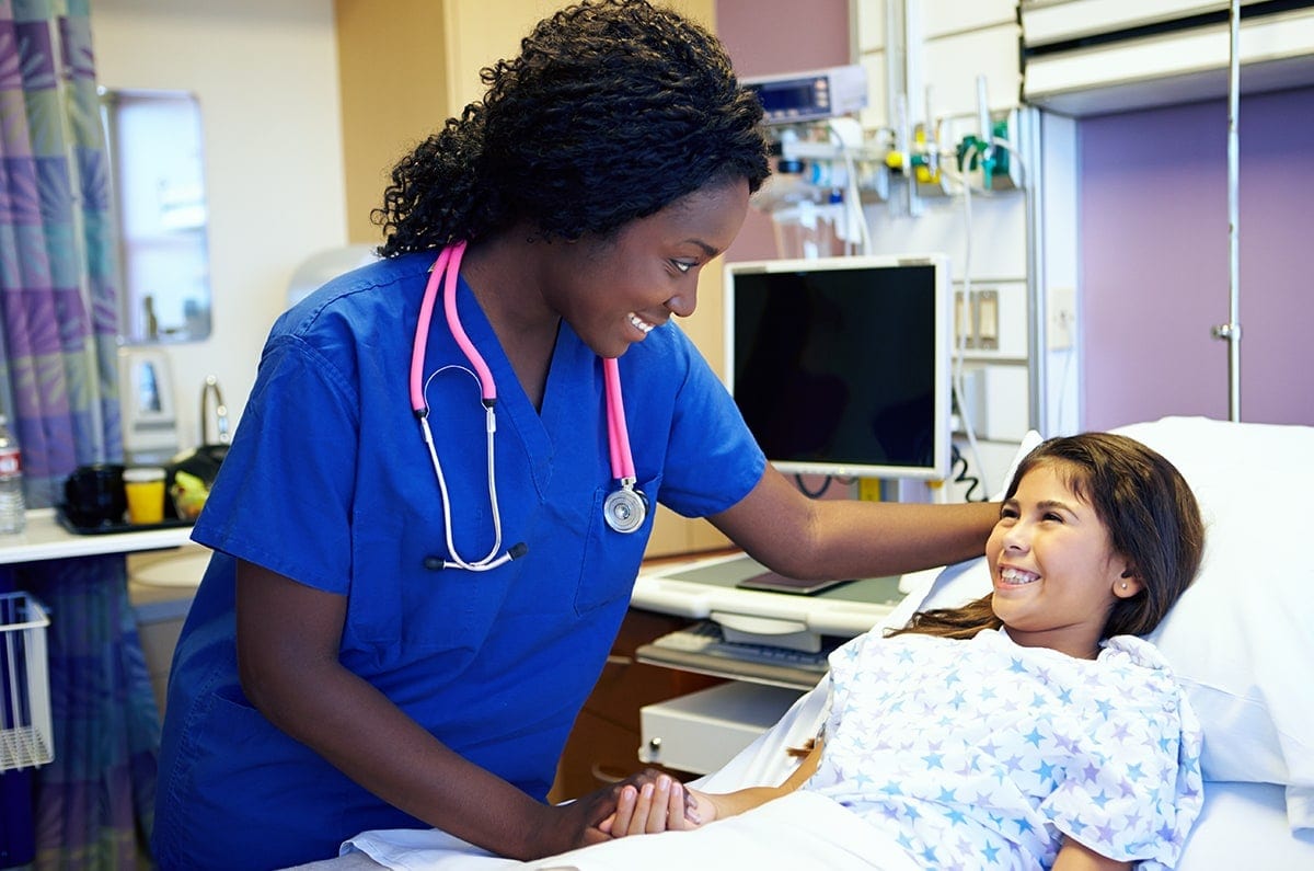 nurse talking to a pediatric patient in bed