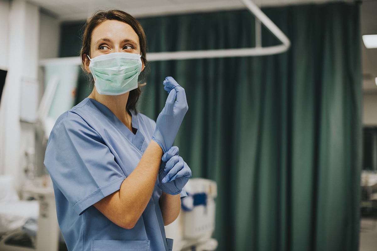 a nurse putting on gloves