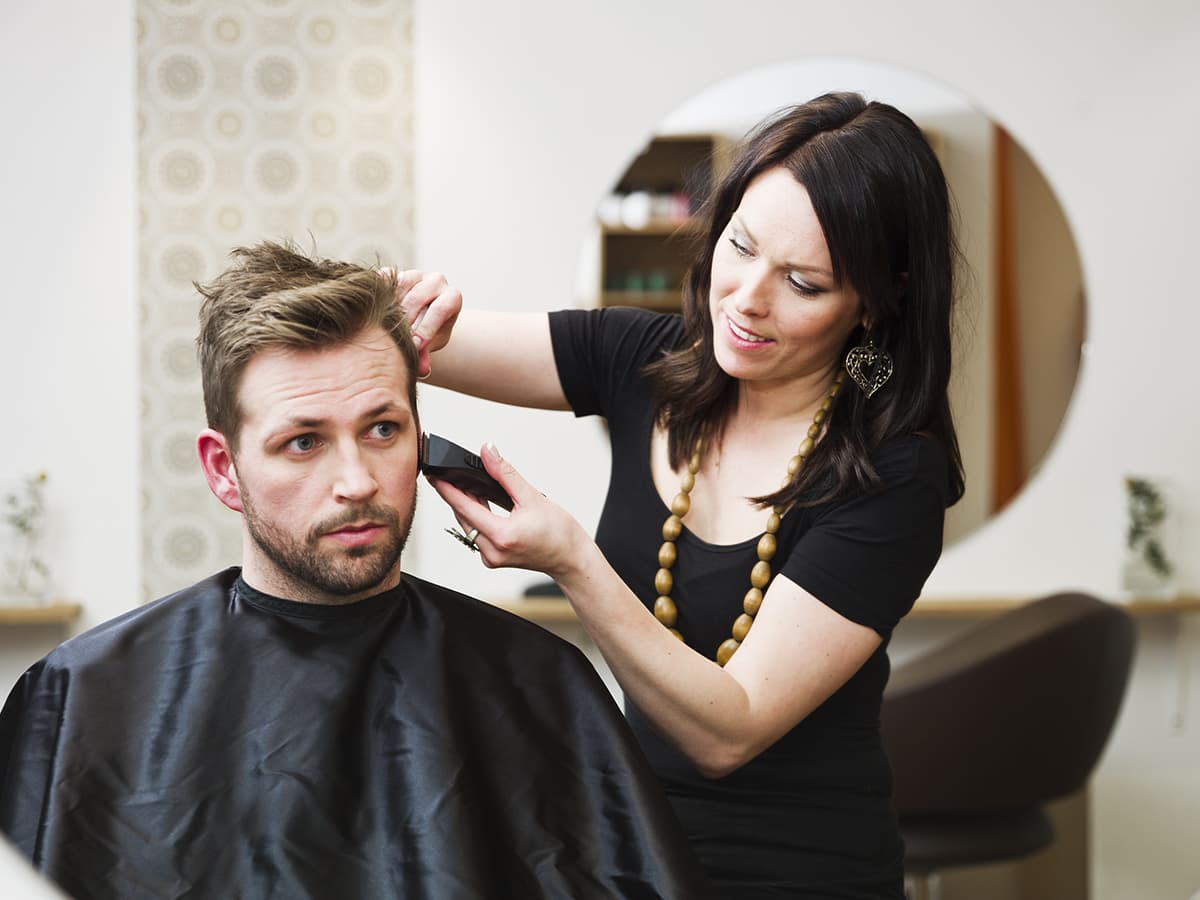 woman barber working on male client