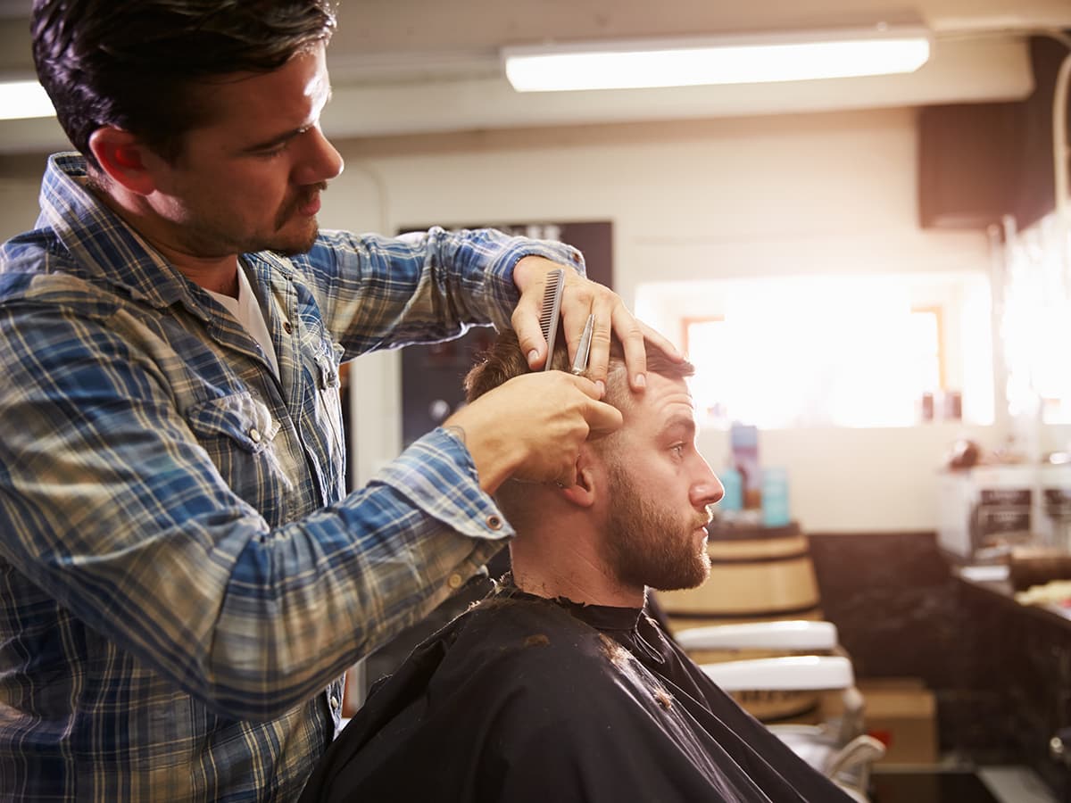 man in barber chair getting a haircut