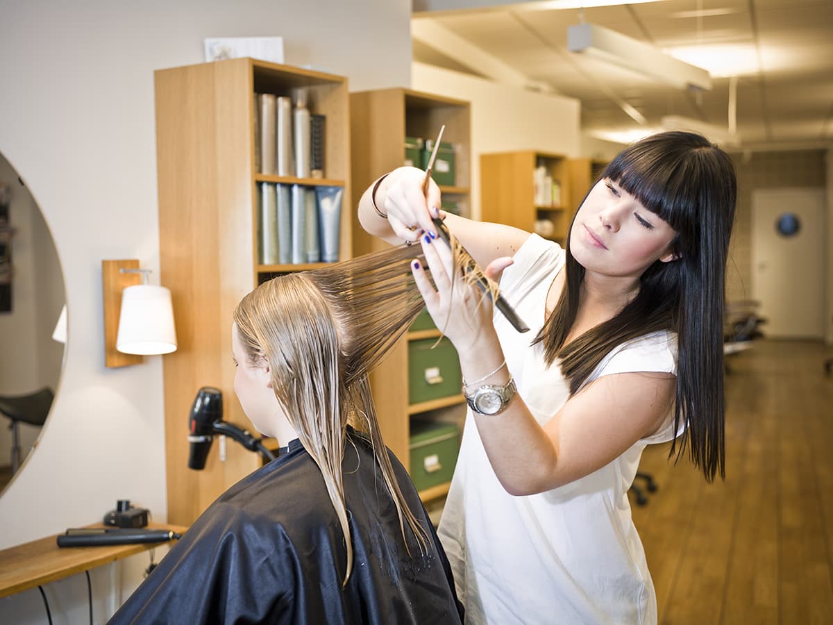 young woman cutting long hair