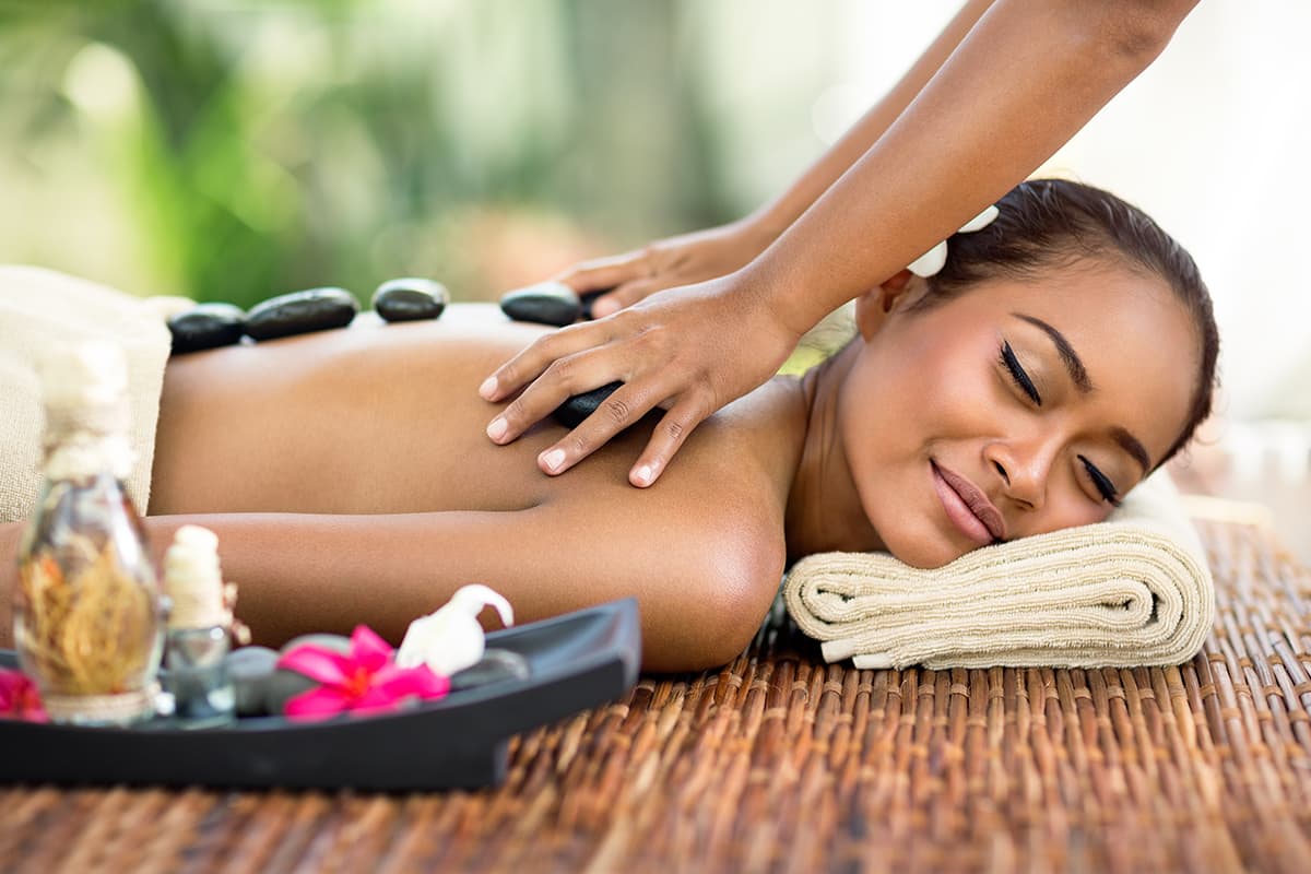 A young woman receiving a hot stone massage.