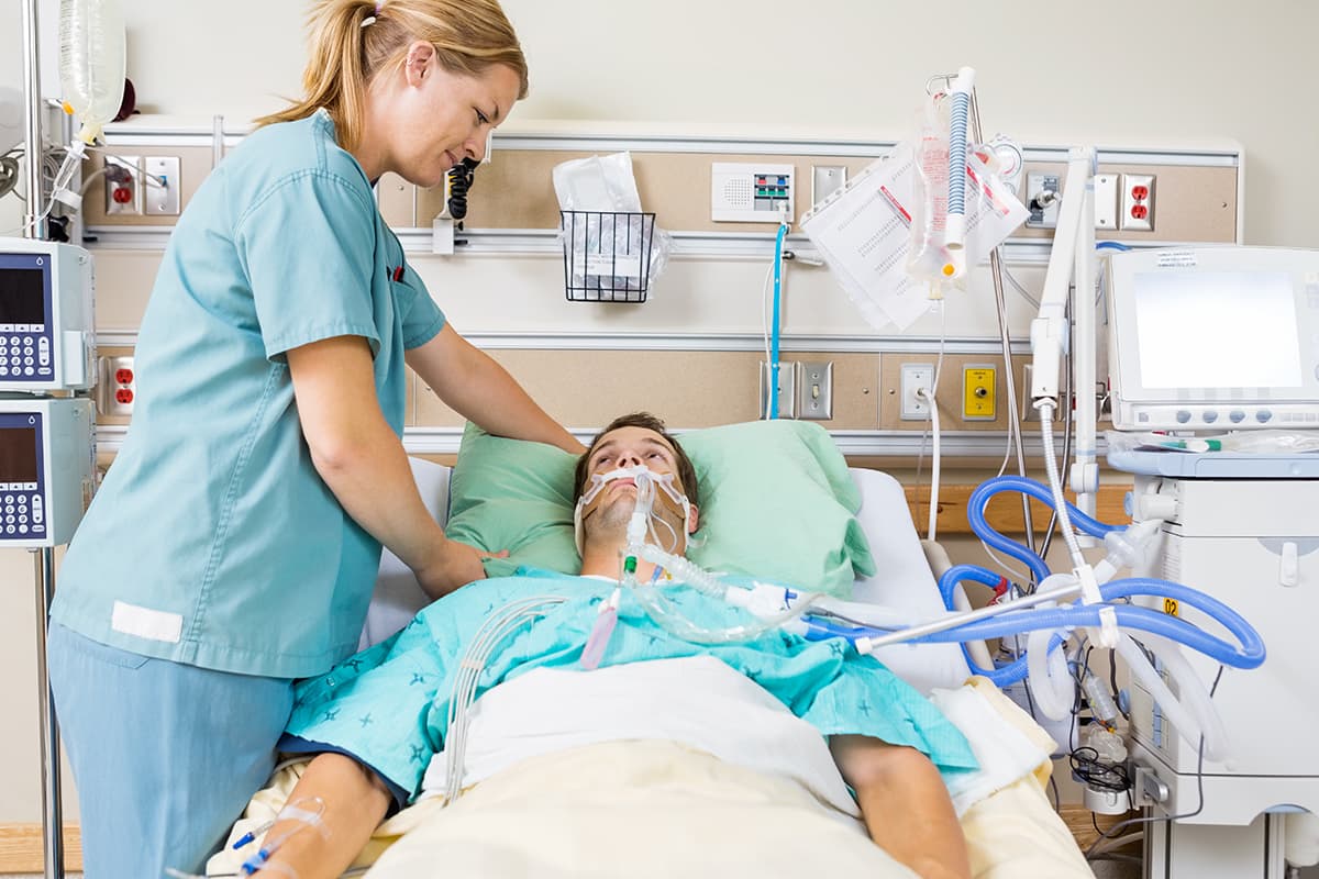 Nurse helping a patient in critical care.